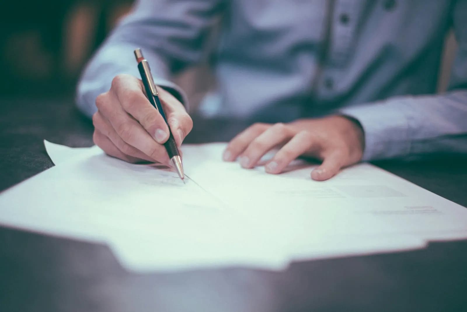 Personne signant un document administratif au stylo