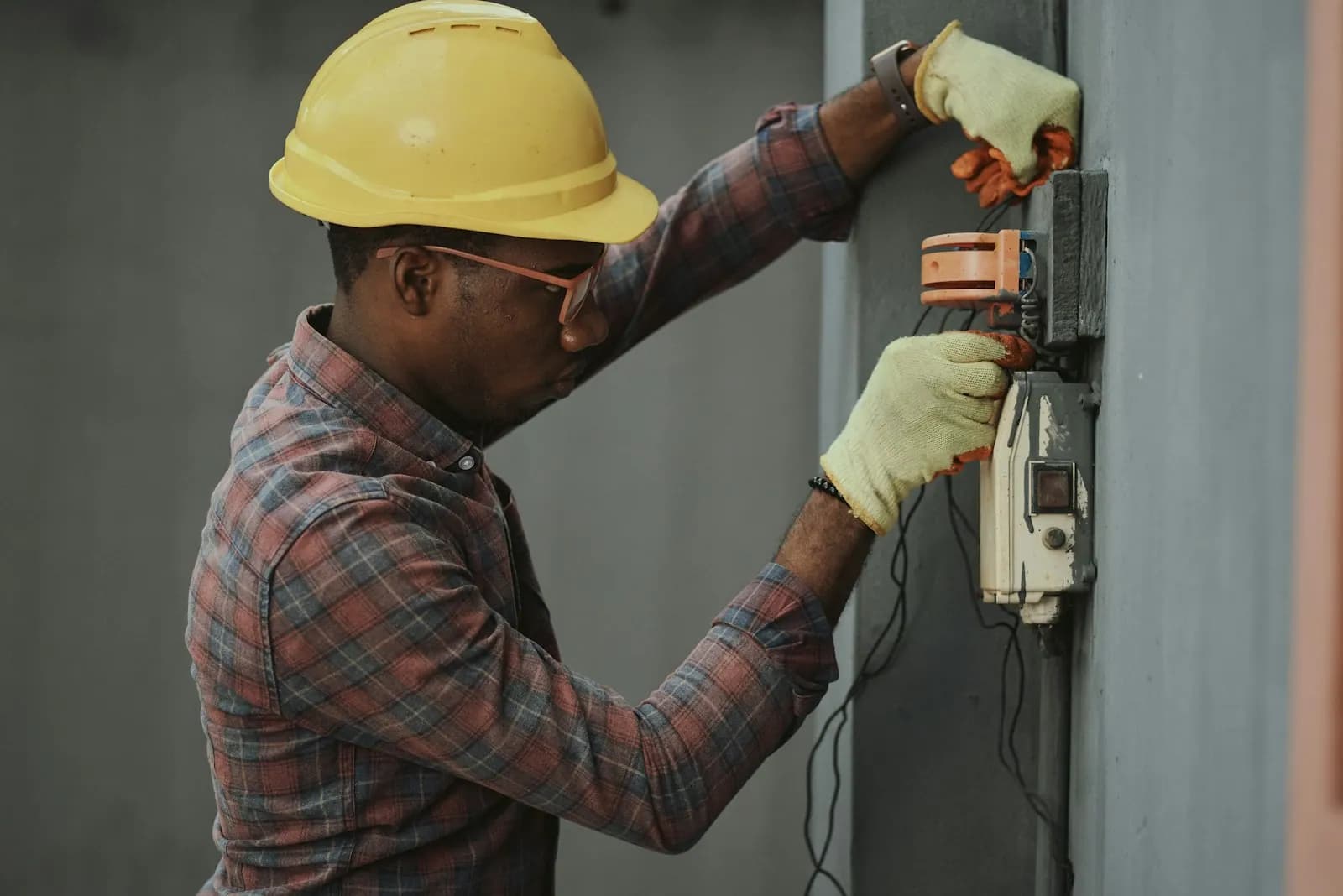 Technicien casqué intervenant sur un tableau électrique extérieur
